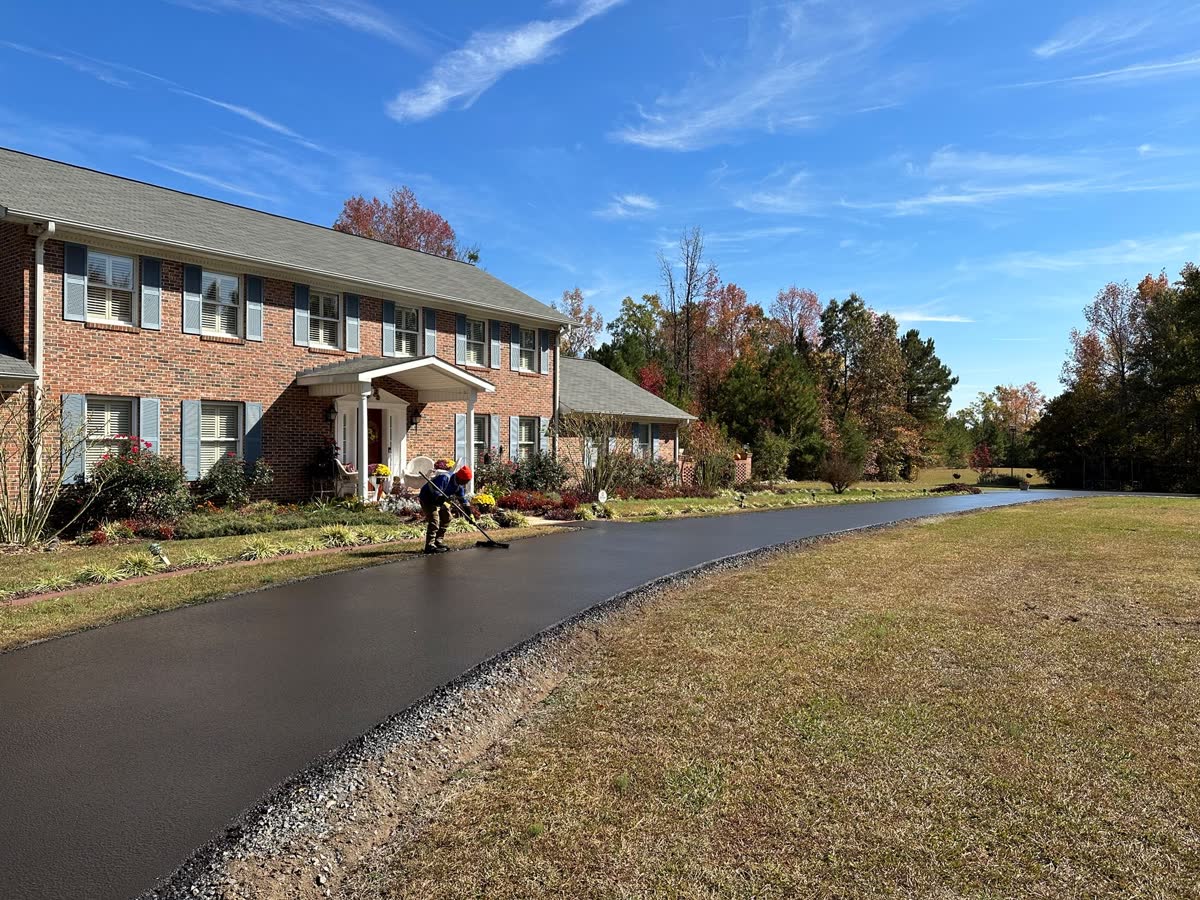 Driveway after sealcoat application with a clean black wet-look finish