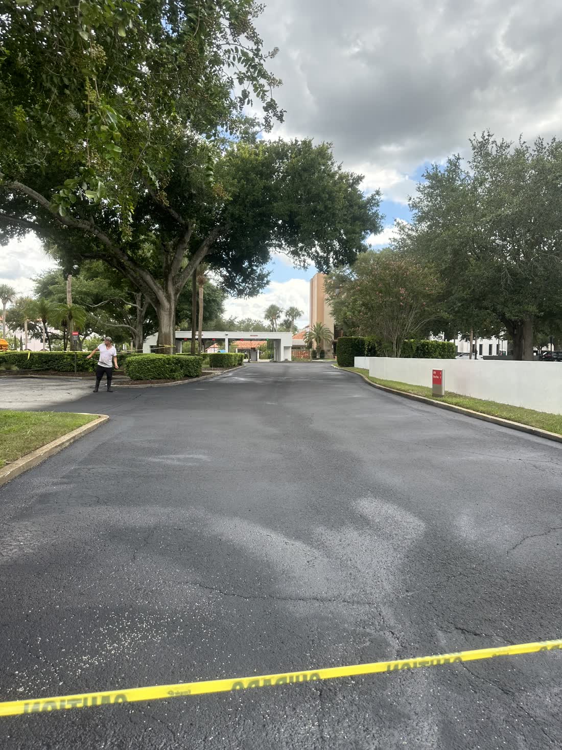 Residential driveway sealcoated to a fresh black finish at a brick home