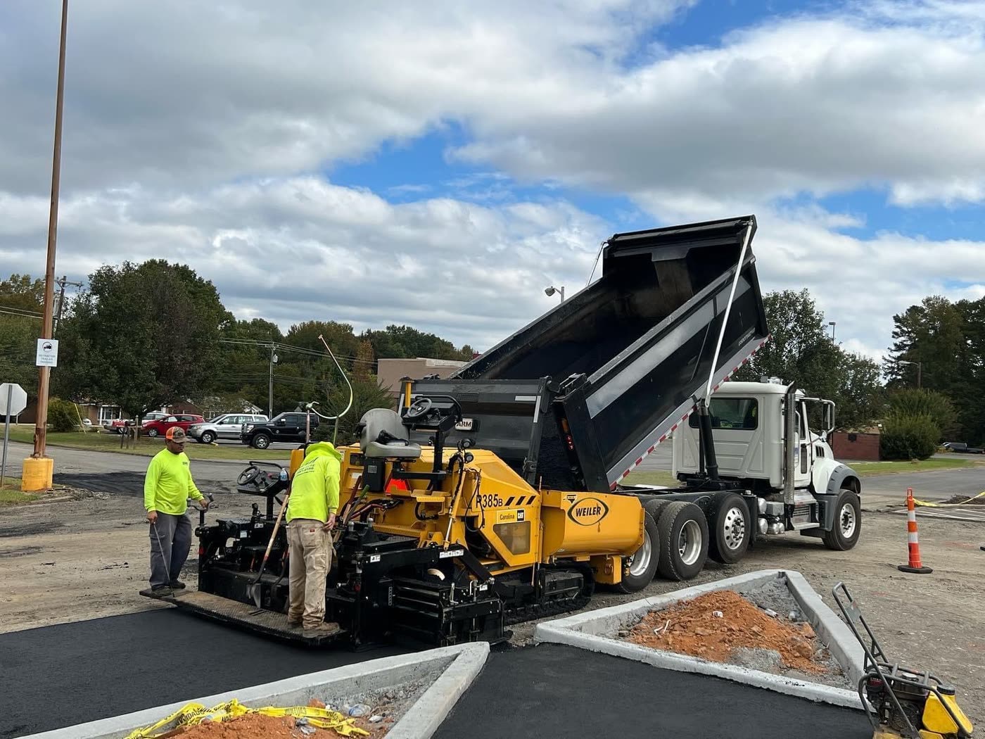 Dependable Paving crew running a Weiler paver with a dump truck behind them
